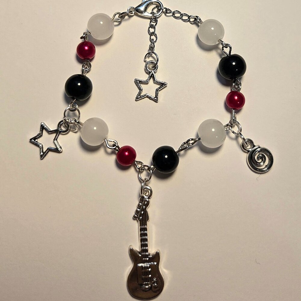 Handmade red, black, and white beaded bracelet with star and guitar charms